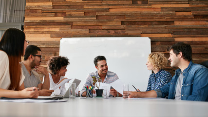 Happy young business people meeting in conference room