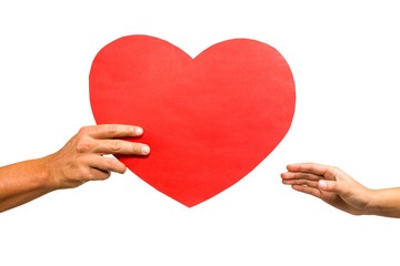 Cropped hand of man giving heart shaped paper