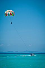 parasailing. So much emotion and excitement of parachuting or just adventure. Underfoot much space . air above you neboy . beautiful clear blue.