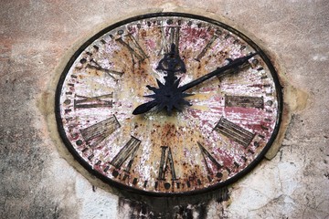 Old weathered clock on a house wall