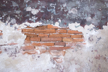 the red brick cracking with the vintage art on the wall
