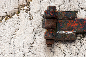 Rusty Hinge on white Rock / Detail of an old rusty hinge with big bolts on a white rock