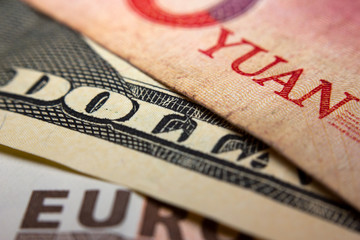 Close-up of an Chinese yuan, an American dollar and a Euro banknote - obrazy, fototapety, plakaty