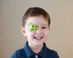 Little boy with okluder on the eye.