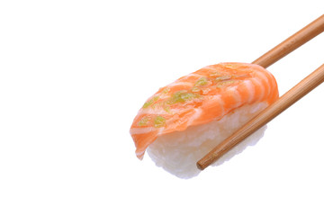 Salmon sushi in chopsticks on background.