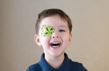 Little boy with okluder on the eye. - obrazy, fototapety, plakaty