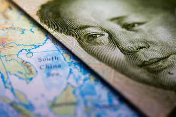 Close-up of Mao Zedong on a 1 yuan Chinese banknote on top of a map showing the South China Sea