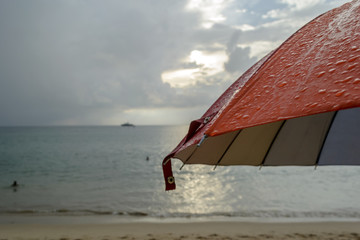 umbrella in the rain and blur beach background - 100715292