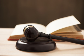 Wooden gavel and a book on wooden table, law concept