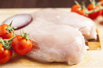 Fresh raw chicken breast with cocktail tomato