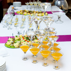 Pyramid of glasses with drinks and wine on banquet table