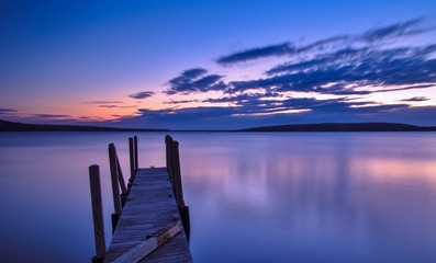 Lake Superior Sunrise. Sunrise over the Lake Superior horizon with a dock in the foreground and...