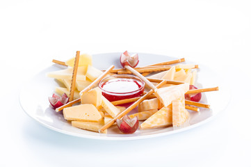 Cheese assorted with crackers, grapes and jam on a white backgro