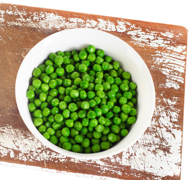 Green peas in a bowl isolated on white.
