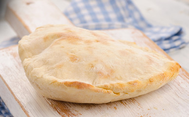 Homemade pita bread on a white wooden board.