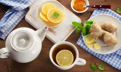 Tea with lemon, ginger, honey  and mint on a wooden background. View from above