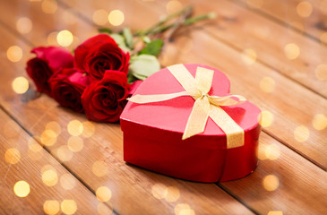 close up of heart shaped gift box and red roses