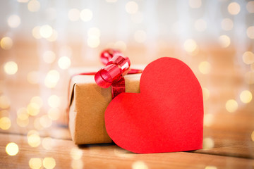 close up of gift box and heart shaped note on wood