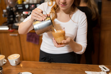 close up of woman making coffee at shop or cafe