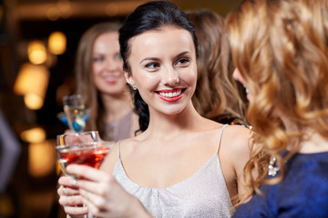 happy women with drinks at night club