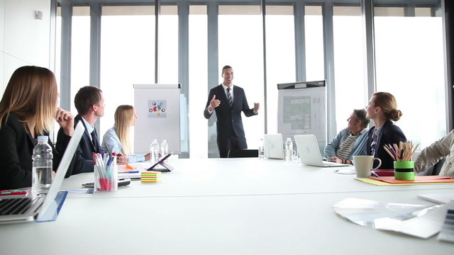 Smiling manager giving presentation to colleagues