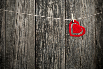 Brown wooden background with red heart without text.