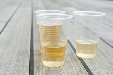 Champagne in plastic cups on wooden table