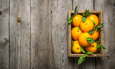 Oranges with leaves in an old box.