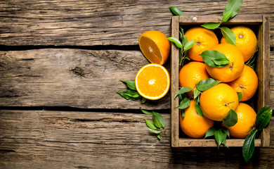 Oranges with leaves in an old box.