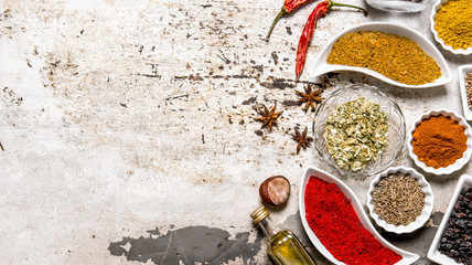 Large set of spices and herbs in the cups.