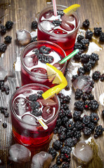 Making cocktail of berries , ice and lemon on wooden background.