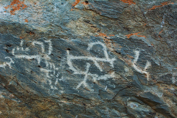 Palaeolithic Petroglyphs carved in rocks. Hunting scenes. Stones with petroglyphs in the Chuya Steppe, Kuray steppe in the Siberian Altai Mountains, Russia