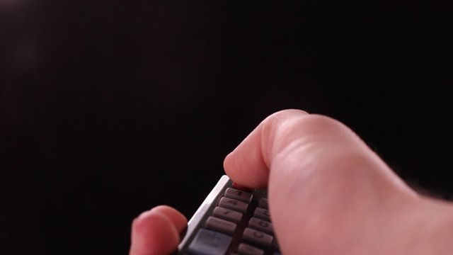 male hand with a remote control to remotely turn off the TV with Chroma Key Green Screen