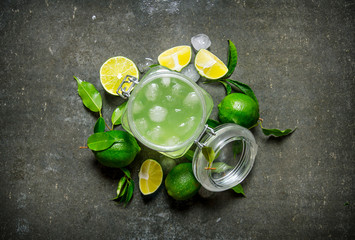 Lime background. The juice from the limes with ice and sliced limes around .