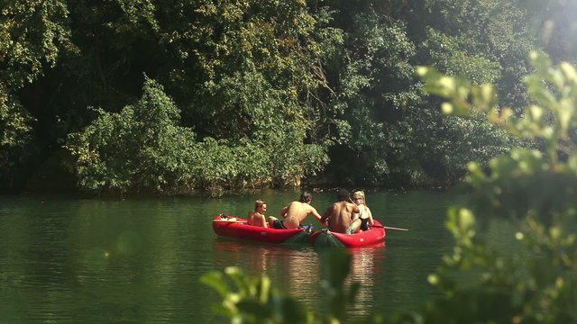Friends enjoying paddling in canoe on river