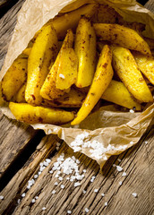Fries with spices and salt on wooden background