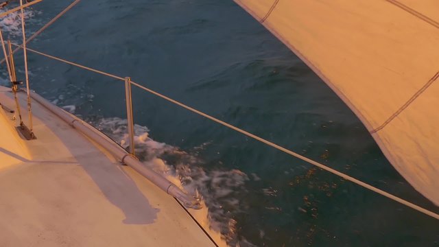 sail boat plowing through water during sunset