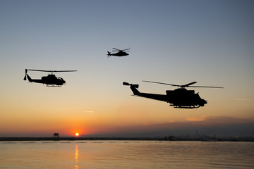 Drei fliegende Armeehubschrauber auf Sonnenunterganghintergrund