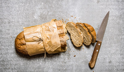 Cut fresh bread with a knife.  Top view