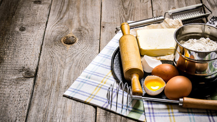 Preparation of the dough. Ingredients for the dough - eggs, butter, flour, salt and tools on the fabric.