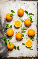 Fresh oranges with leaves. On rustic background.