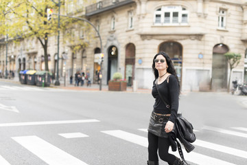Obraz na płótnie Canvas Woman with sunglasses heavy metal style walking in the street.
