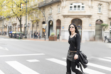 Woman with sunglasses heavy metal style walking in the street.