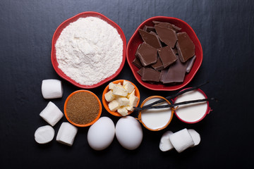 Ingredients for sweet pastry on a black wooden background