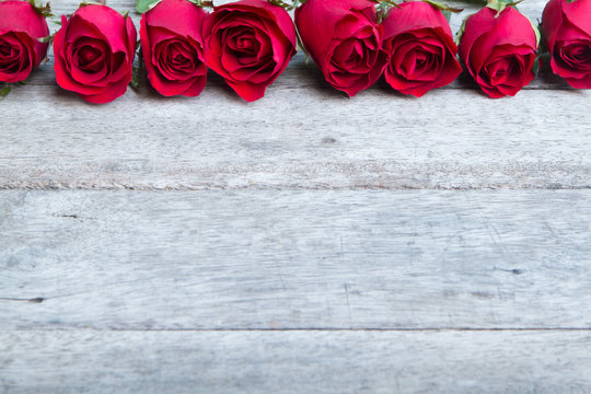 Red roses on woonden background. Valentine's day background.