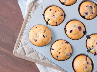 Wild berries muffins on wooden table with table napkins