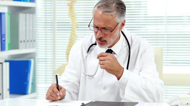 Portrait of a serious doctor working on his desk