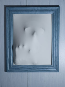 Creepy Bluetone Picture Frame with Something Coming Out of It