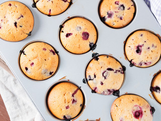 Just baked sweet yogurt muffins with blackberries, blueberries and raspberries in a muffin tin