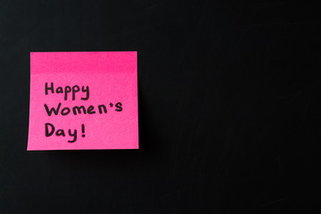 Happy Women's Day. Pink sticker on black chalkboard